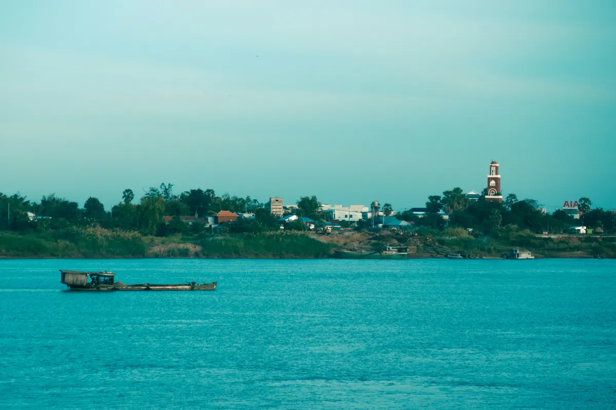 Barque sur le Mekong au coucher du soleil, ciel dore