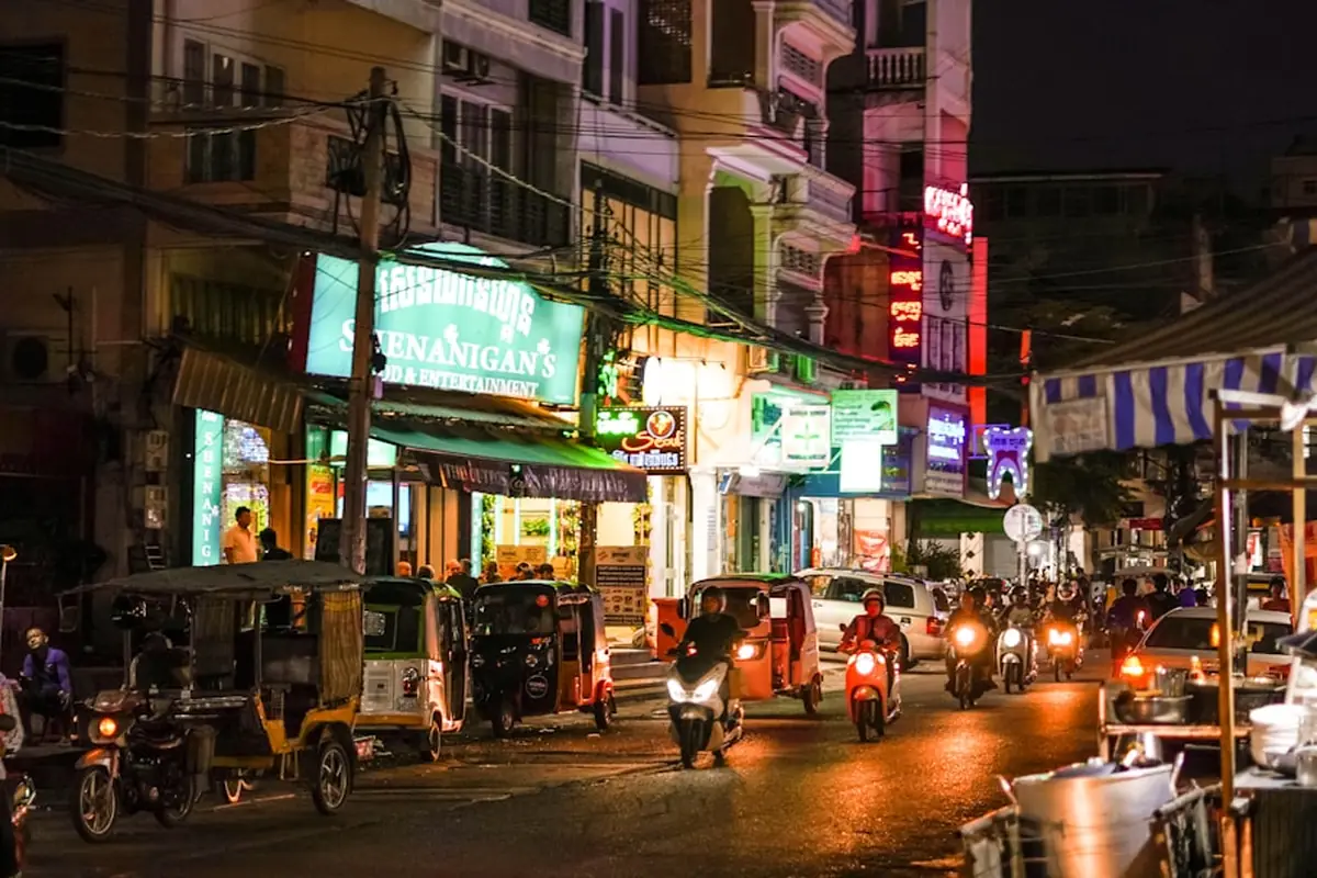 Passants dans une rue cambodgienne animée la nuit