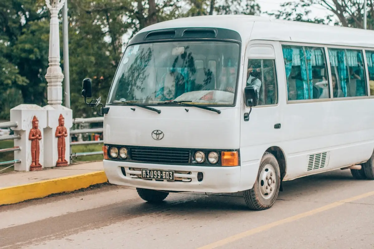 Bus blanc garé sur une route dans un paysage tropical